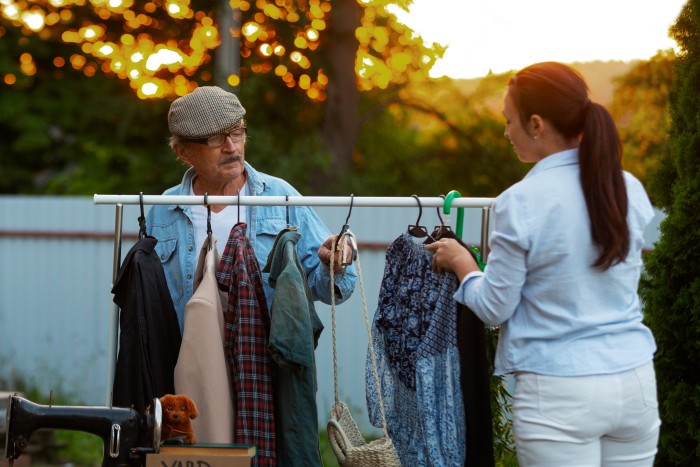 Eco-Friendly Dry Cleaning: A man and woman sorting and hanging clothes outdoors for reuse or sustainable garment care.
