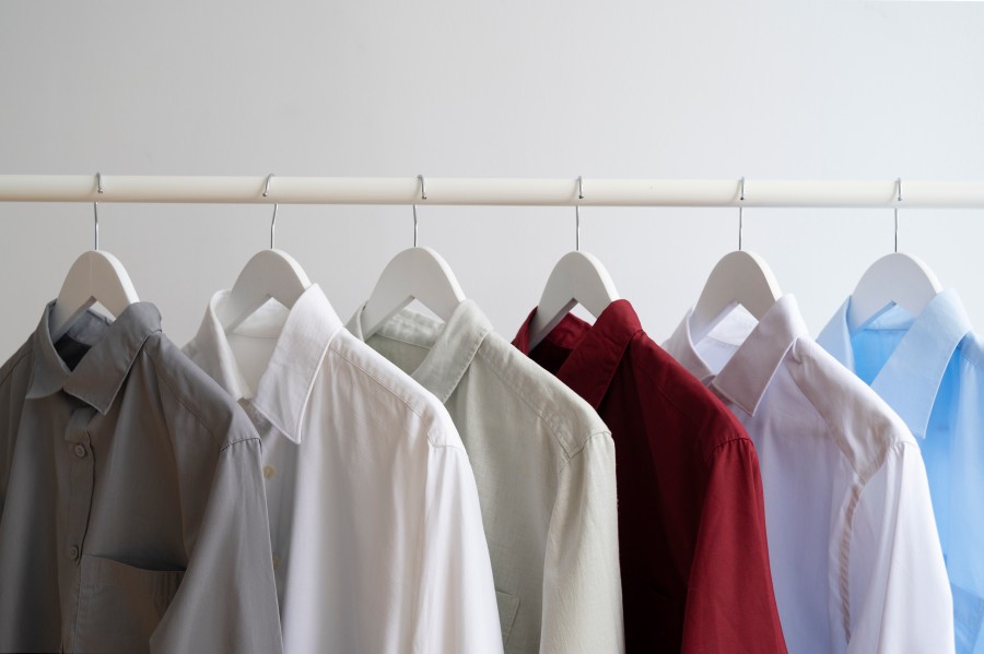 Premium Dry Cleaning Services for neatly hung shirts in gray, white, green, red, and blue.